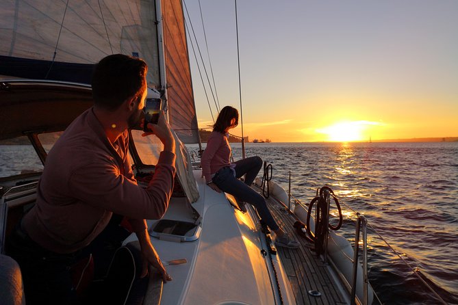 Lisbon Sunset Sailing Tour on Luxury Sailing Yacht with 2 Drinks - Christ the King, Alfama angles, and castle silhouettes