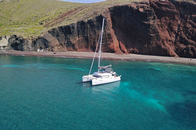 Santorini: Luxury Catamaran Cruise with Fresh Fish BBQ & Drinks - Mesa Pigadia’s black sand and the south-coast lighthouse moment